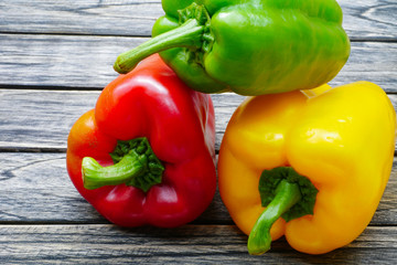 Sweet red green yellow bell pepper on wooden background