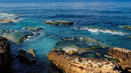 coast with rocks at the sea, clear blue and emerald colored water