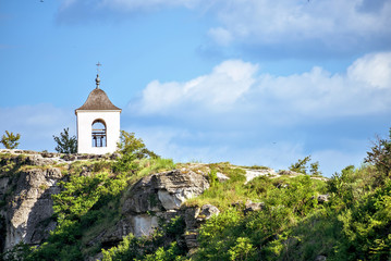 Wonderful landscape with rocks and mountains at orheiul vechi monastery and memorial in moldova, near raut river, blue sky, sunny day, bell tower