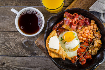 Full english breakfast - eggs, bacon, beans, toast, coffee and juice