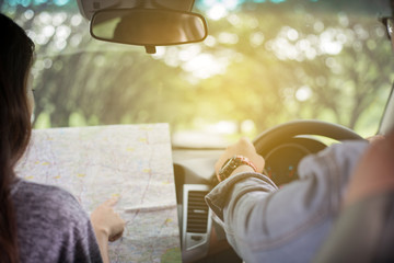 Asian man and woman using map on roadtrip and Happy young couple with a map in the car. Blurred and Soft focus