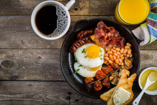 Full english breakfast - eggs, bacon, beans, toast, coffee and juice