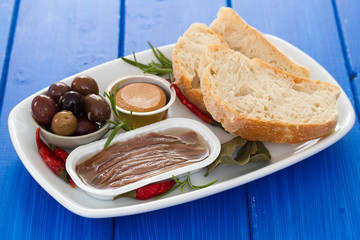 anchovies, olives, bread and fish pate on dish