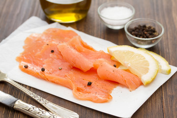 smoked salmon with lemon on white dish