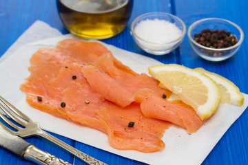 smoked salmon with lemon on white dish