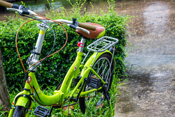 Fototapeta na wymiar Green bike in the middle of the rain, making it sad because it's single.