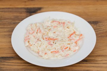 cabbage salad on white plate on wooden background