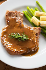 grilled pork chop with gravy serve with asparagus and baby corn
