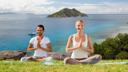 happy couple doing yoga and meditating outdoors