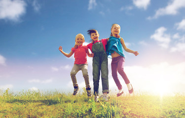 group of happy kids jumping high on green field