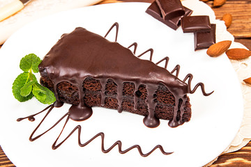 Piece of cake on white plate garnish with mint and raspberry.