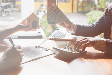Fototapeta premium realtor talk with his clients. real estate agent have a deal with a couple. House developer and customer have a meeting. sale and purchase property with house model and signing contract document. 