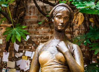 Fototapeta na wymiar bronze statue Juliet stands on a street in Verona, Italy