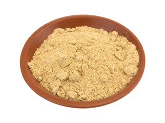 Seasoning mix for beef stew in a small red clay bowl isolated on a white background.