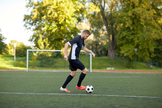 soccer player playing with ball on football field