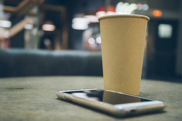 coffee cup with mobile phone on the table