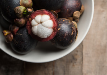 Top view of mangosteen fruit in the bowl over wooden table background