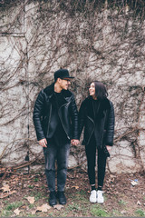 Young couple posing holding hands looking in the eye, smiling - love, romance, tenderness concept