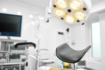 Selective focus on a part of gynecological chair in an operating theatre at the hospital surgical lamp on the background copyspace healthcare medicine gynecology concept.