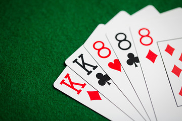 poker hand of playing cards on green casino cloth