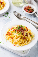 Italian pasta spaghetti Carbonara with fried bacon, parmesan cheese and parsley on white plate. Restaurant food consept.