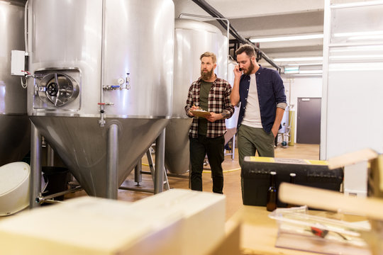 men working at craft brewery or beer plant