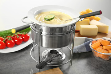Cheese fondue and vegetables on table
