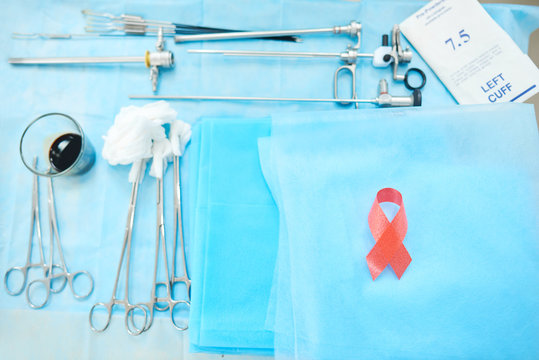 Top view of surgical tools and instruments lying on the table with a pink ribbon breast cancer awareness surgery sterile healthcare health medicine concept.