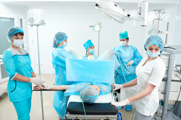 Team of professional experienced doctors during surgery in operating theatre of the hospital people profession occupation routine medicine clinical healthcare patient concept.