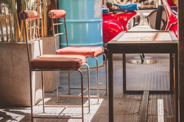 Old steel chair and steel table with sunlight in coffee shop.