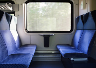 Fototapeta premium Five blue seats facing each other in modern European train