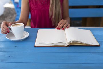 Young attractive woman in cafe with notebook and espresso