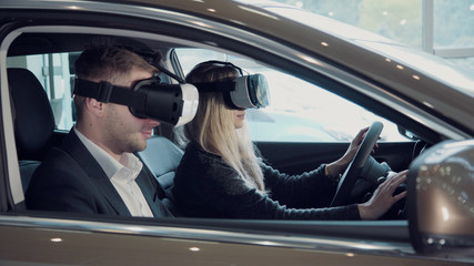 Young woman going for a test drive with the salesman in a new car as she makes a selection for her...
