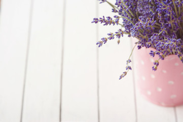 Lavender flowers in watering can, wooden background, copy space