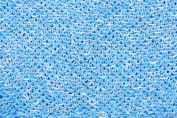 The texture of a knitted woolen fabric in blue and white color. Natural background. 