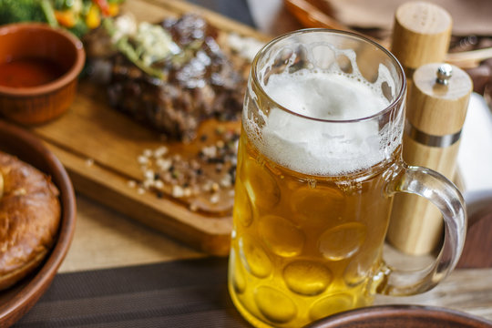 Beer mug and fried meat with vegetables