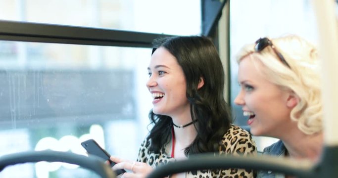 Female friends travelling through London on a bus