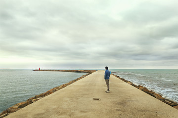 man looking at the lighthouse in seascape