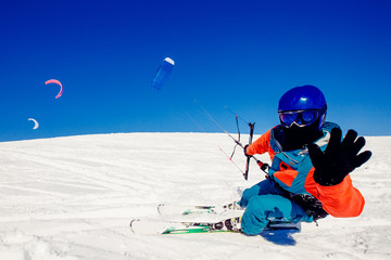  Skier with a kite on fresh snow in the winter in the tundra of Russia against a clear blue sky. Teriberka, Kola Peninsula, Russia. Concept of winter sports snowkite on ski.