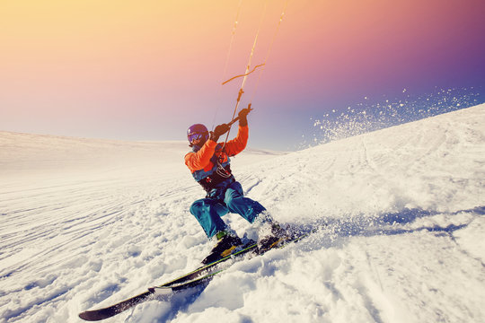  Skier with a kite on fresh snow in the winter in the tundra of Russia against a clear blue sky. Teriberka, Kola Peninsula, Russia. Concept of winter sports snowkite on ski.