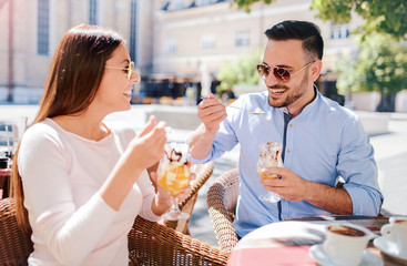 Dating in the cafe. Loving couple drinking coffee and eating fruit desserts. Dating, love, relationships