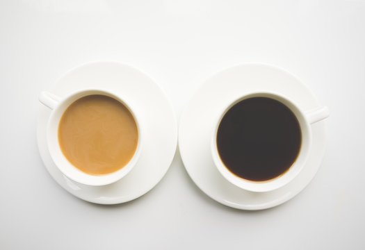 Cup of coffee with milk and black on a white background. Top view