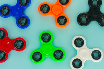 fidget spinners on blue background close up, popular relaxing toy, generic design