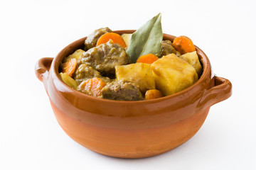 Beef meat stewed with potatoes, carrots and spices in ceramic bowl on wooden table
