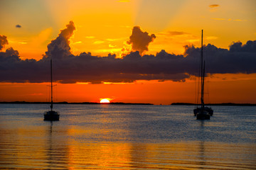 sunset over bay with anchored boats 