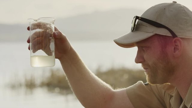 Close up of park ranger collecting water sample from lake. Vineyard, Utah, United States