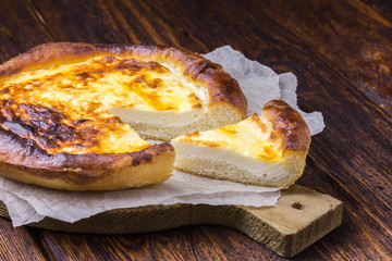 Traditional pastry - vatrushka on parchment paper on wooden table. 