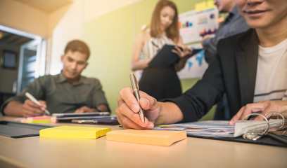 Brainstorming Group of people Working Concept. Business team brainstorming. Marketing plan researching. Paperwork on the table, laptop and mobile phone.