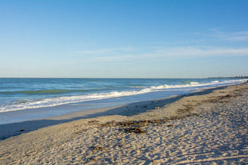 Fototapeta na wymiar sandy beach with low tidel rolling in 