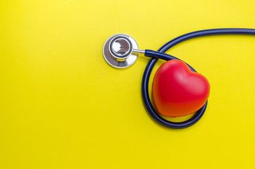 red heart and stethoscope on yellow background, heart health care and medical technology concept, selective focus, copy space